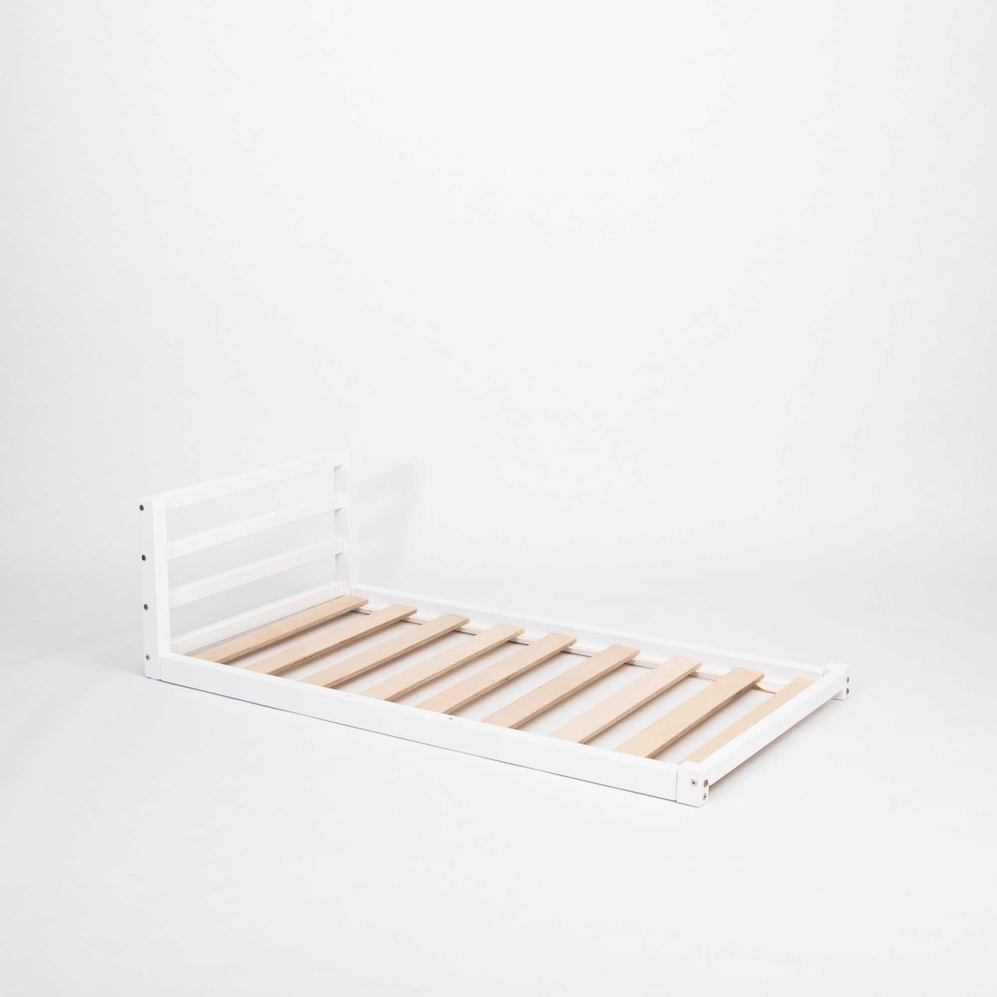 A Sweet Home From Wood toddler floor bed with a horizontal rail headboard, perfect for independent sleeping.