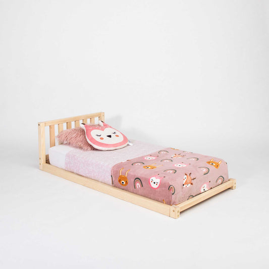 A Sweet Home From Wood toddler bed with a headboard, pink pillow, and a pink blanket.