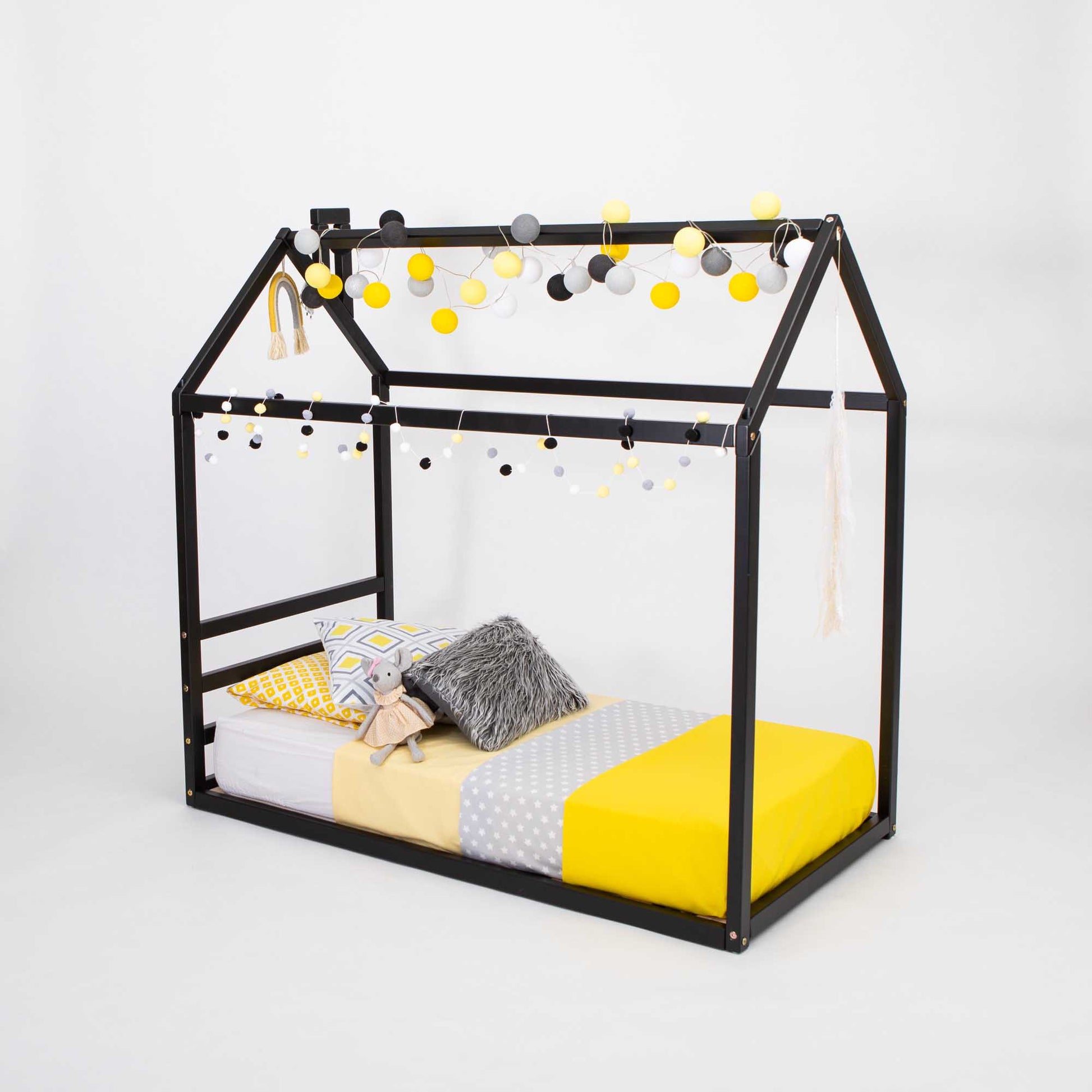 A cozy sleep haven with a Sweet Home From Wood Children's house bed with a horizontal headboard and yellow pillows.