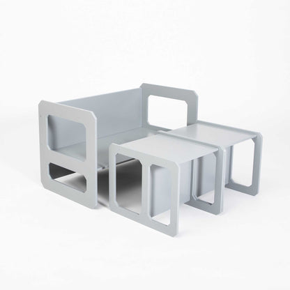 A grey sofa with a Montessori weaning table and 2 chair set on top.