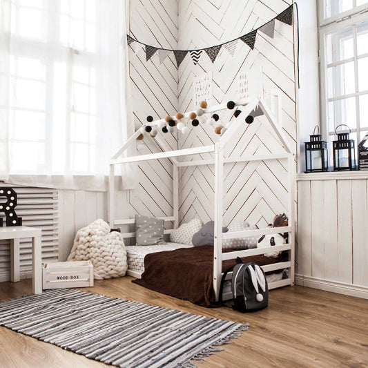 A child's room with a floor house-frame bed with a horizontal headboard and footboard.