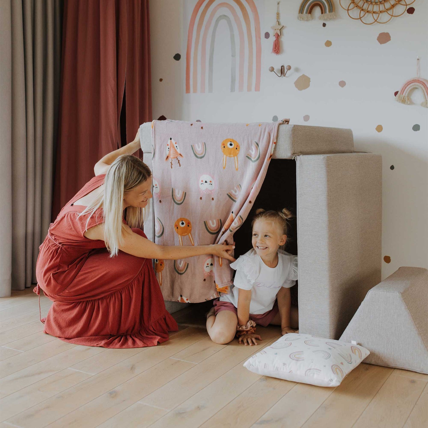 A woman and a child playing with an Activity play couch set from Sweet HOME from wood in a play house.