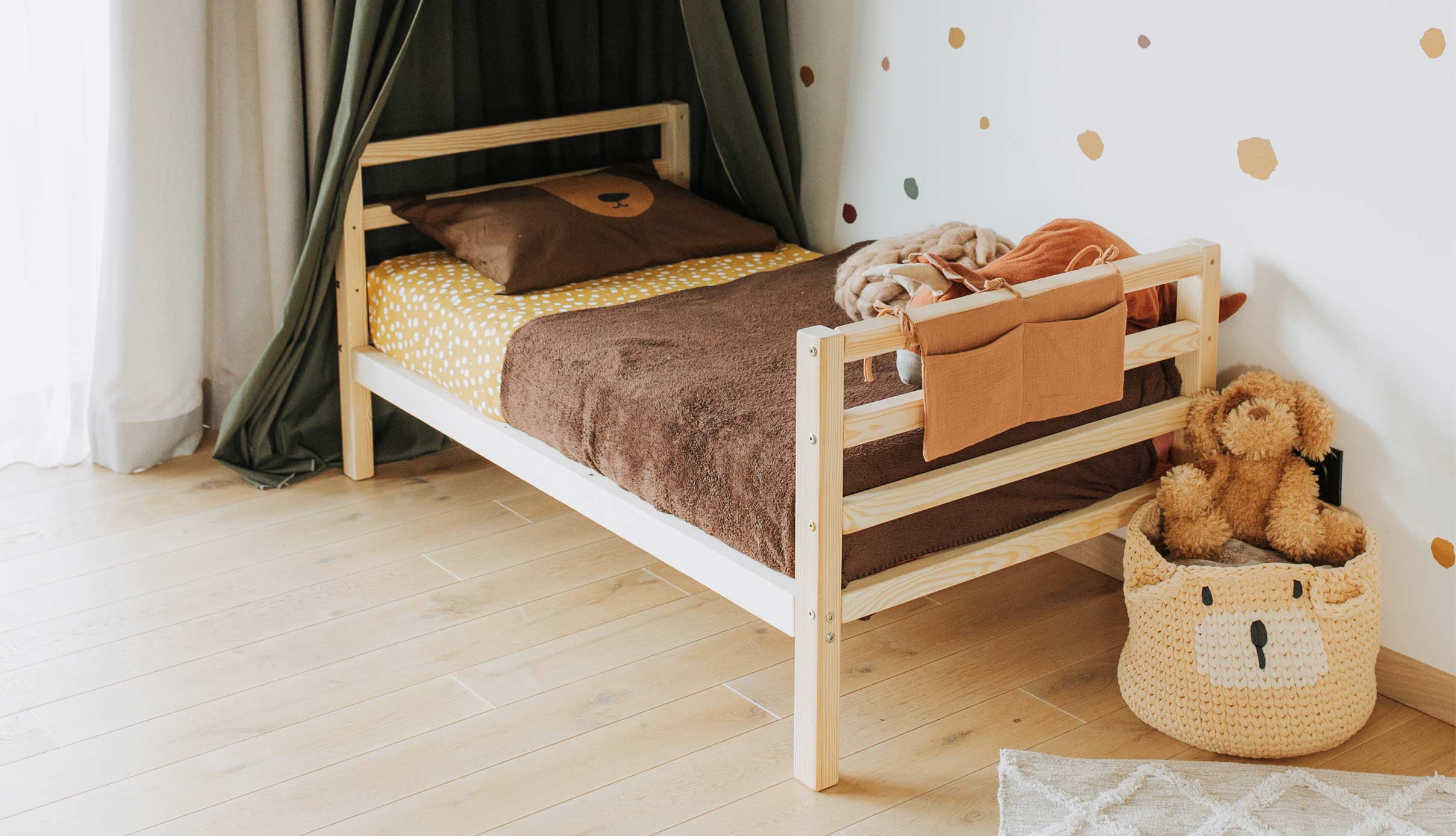 A child's room with a bed and teddy bears.