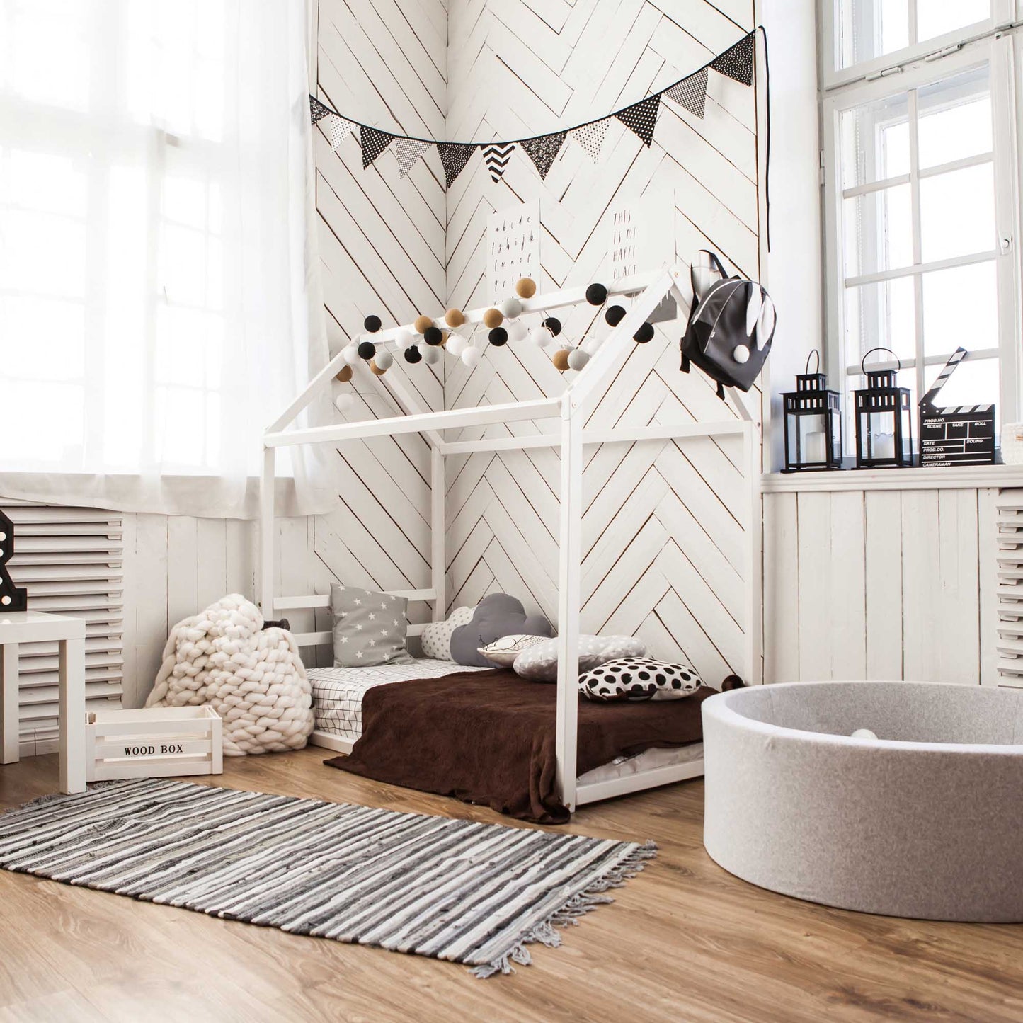 A cozy sleep haven for a child with a Sweet Home From Wood Children's house bed with horizontal headboard and a rug.