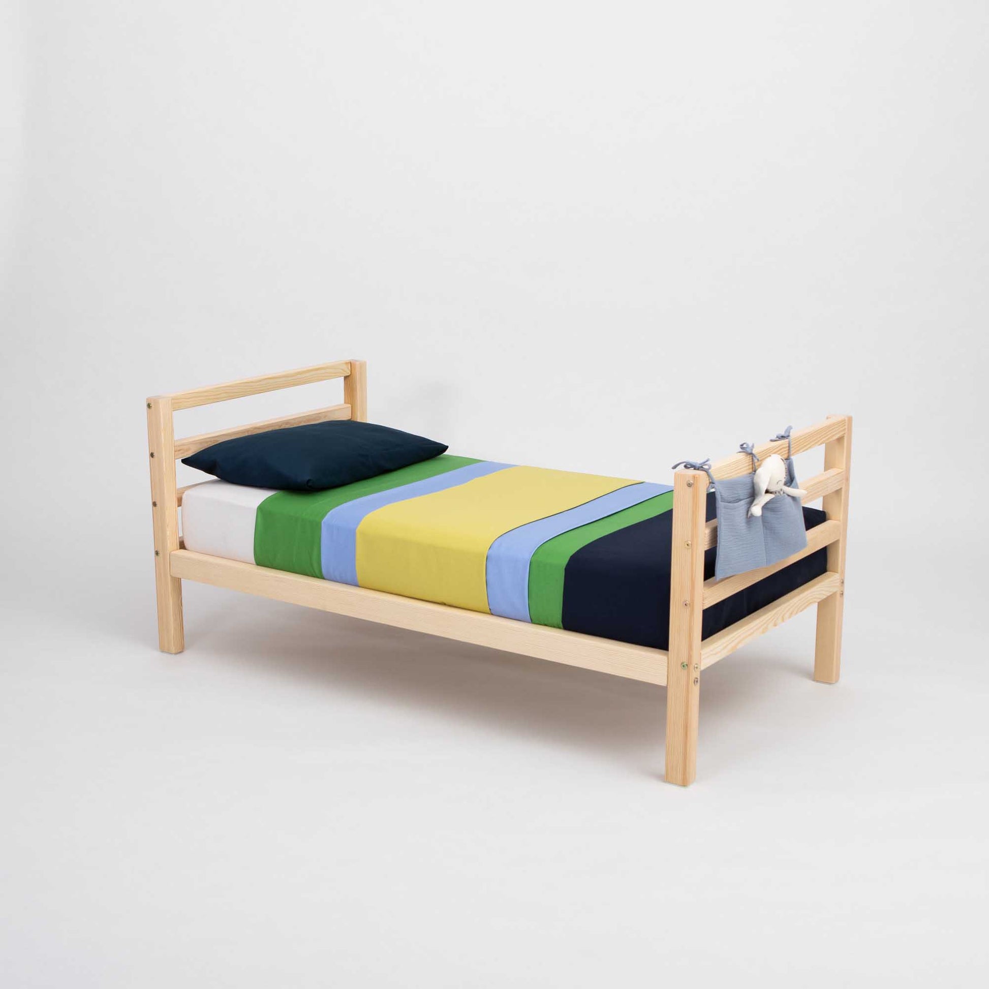 A colorful striped sheet adorns a Sweet Home From Wood kids' bed on legs with a horizontal rail headboard and footboard, making it the perfect option for either boys or girls.