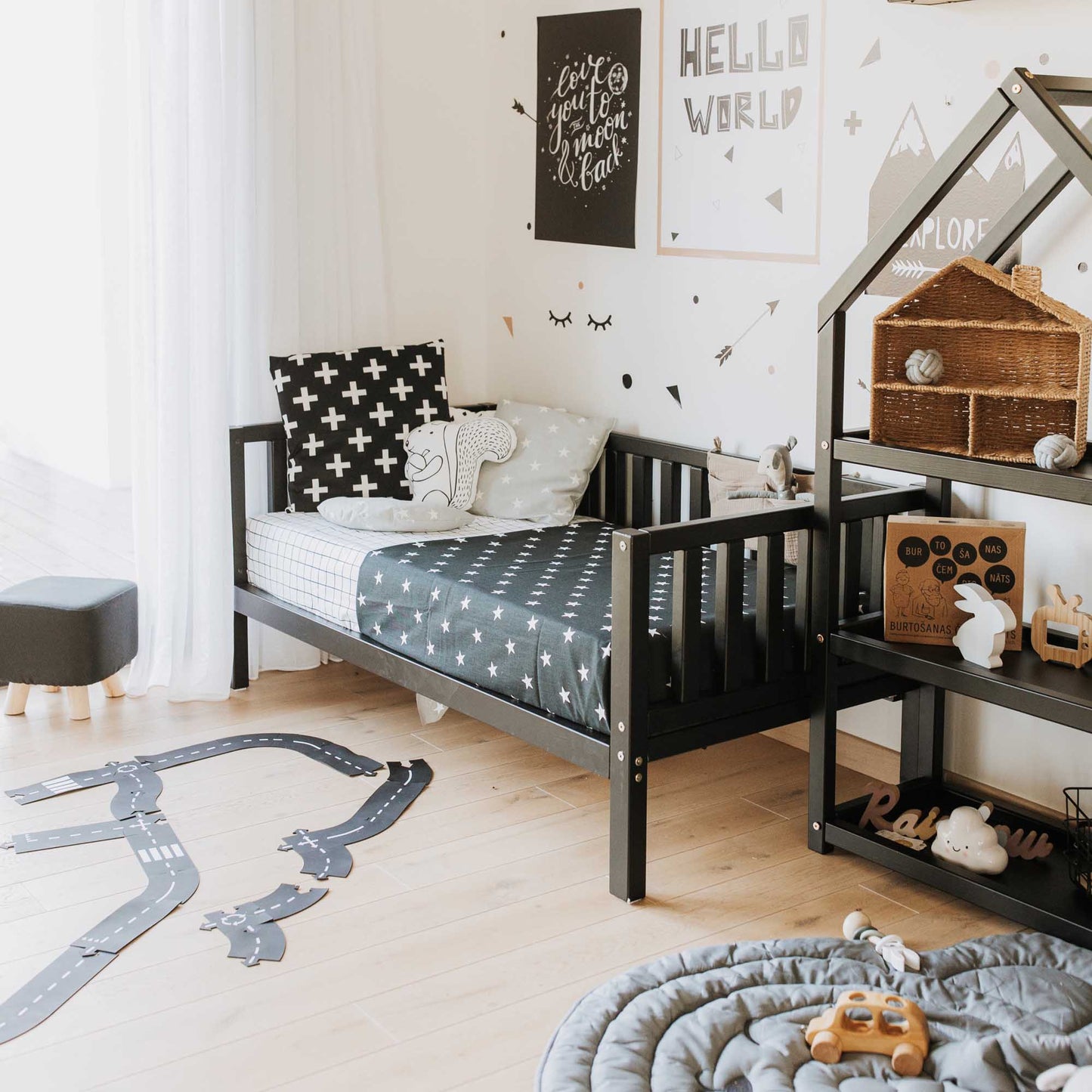 A Montessori-inspired children's room with a Sweet Home From Wood kids' platform bed on legs with 3-sided rails and toys.