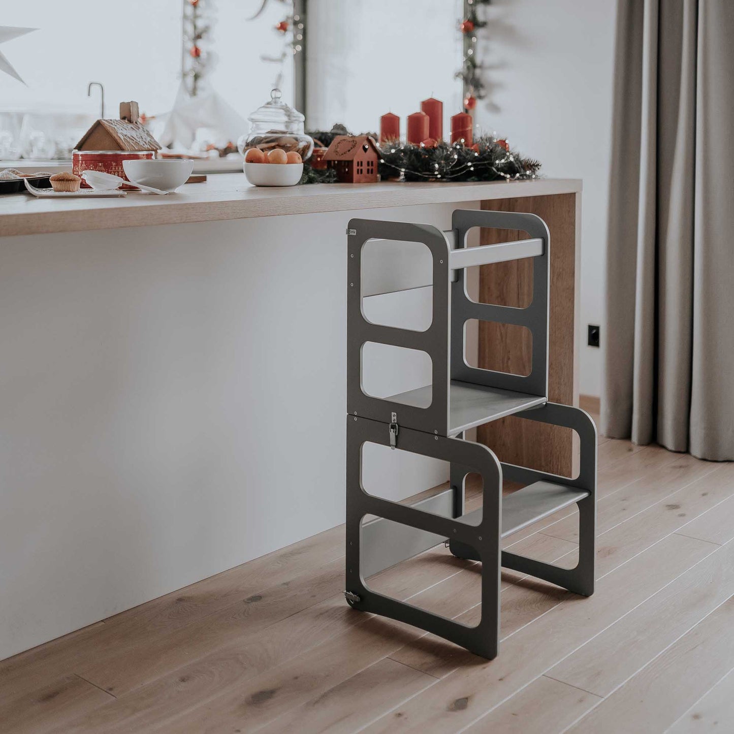 A small kitchen with a wooden table and chairs, equipped with a 2-in-1 transformable Montessori step stool - table and chair set.