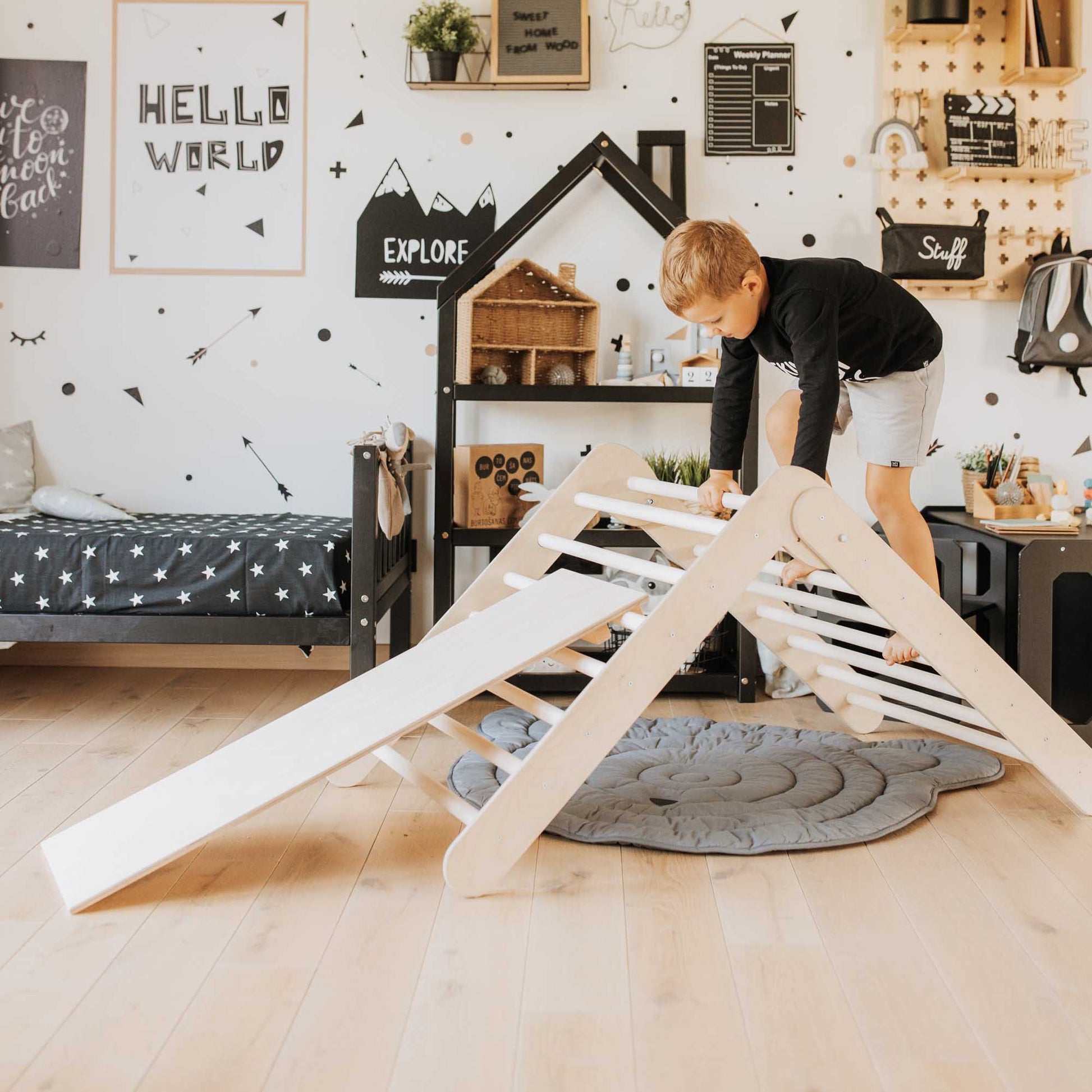 A toddler is playing with a Foldable climbing triangle, Transformable climbing gym, and a ramp in his room.