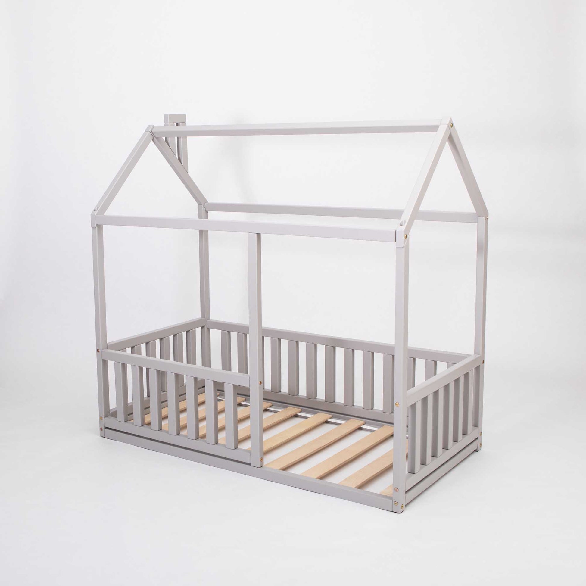 A Montessori floor house bed with rails made by Sweet Home From Wood, featuring a wooden slatted frame.