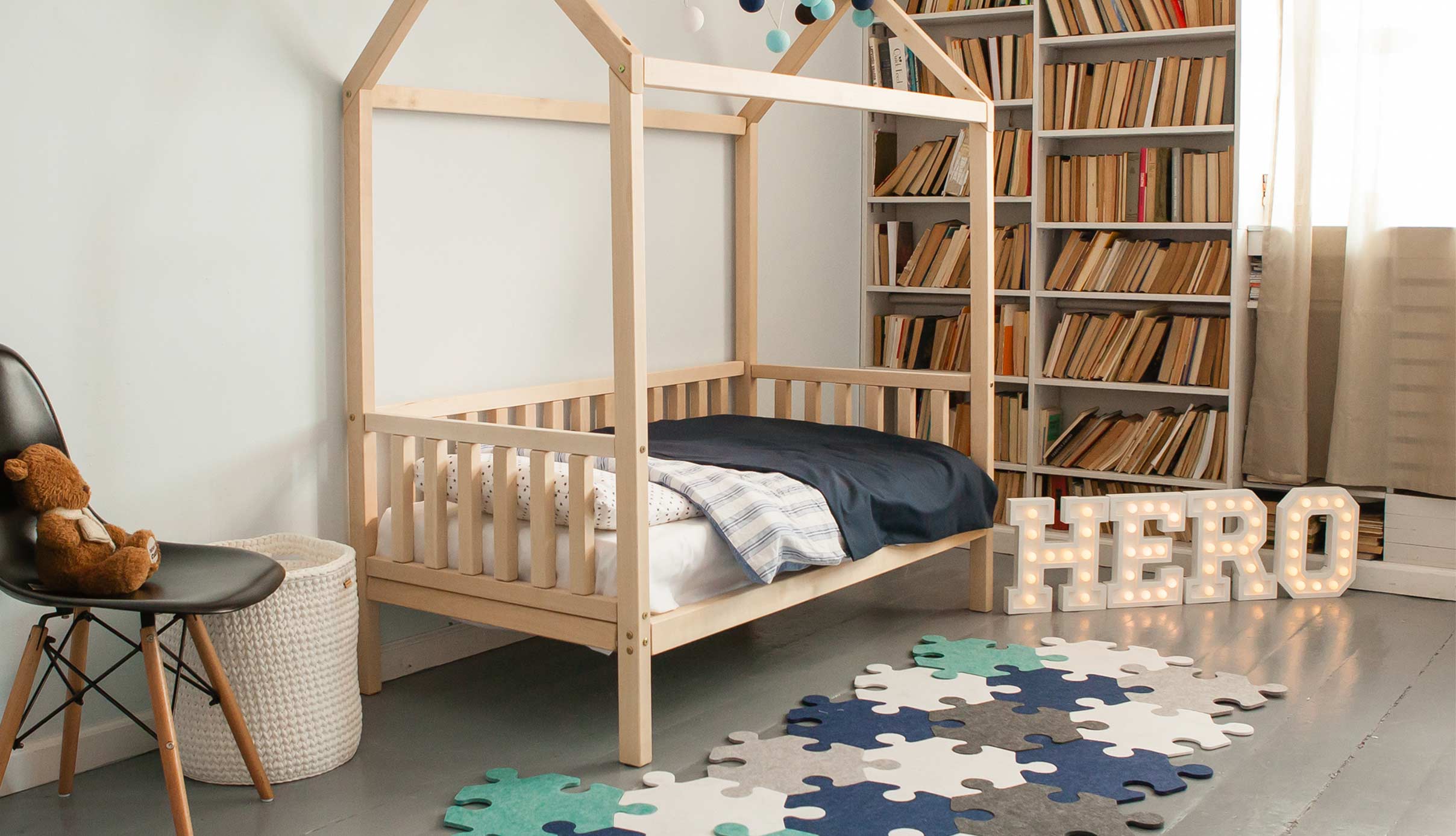 A child's room with a wooden bed and bookshelves.
