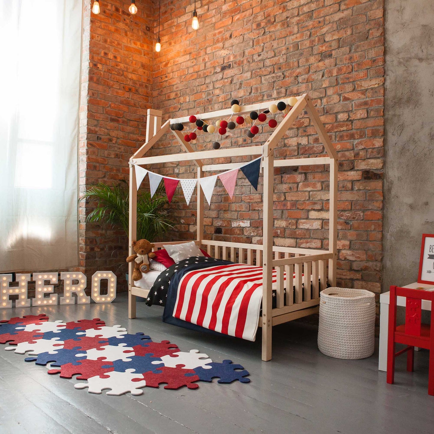 A child's bedroom featuring a Raised House Bed on Legs with 3-Sided Rails in a red, white and blue theme.