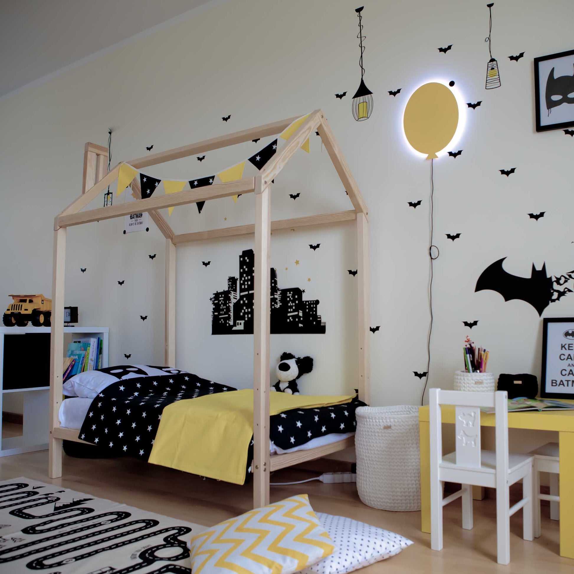 A black and yellow bedroom with a raised wooden house bed on legs.