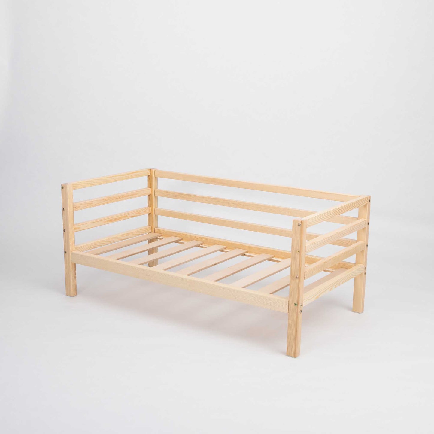 The Kids' bed on legs with horizontal rail on 3-sides is a solid wood, Montessori-inspired toddler daybed featuring slatted sides and base for safety and style, shown against a plain white background.