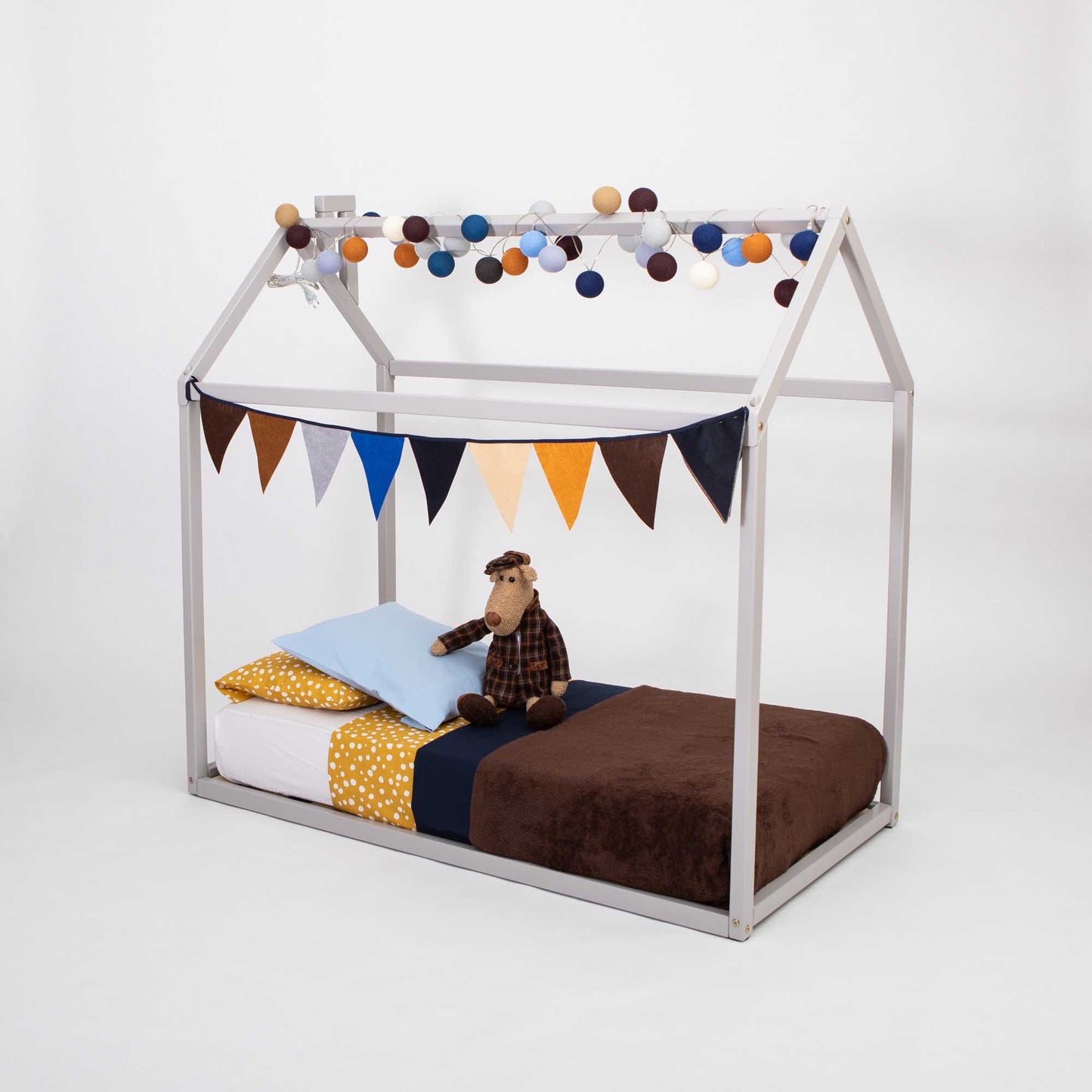 A Sweet Home From Wood Wooden zero-clearance house bed adorned with a cozy sleep haven featuring a teddy bear and bunting.