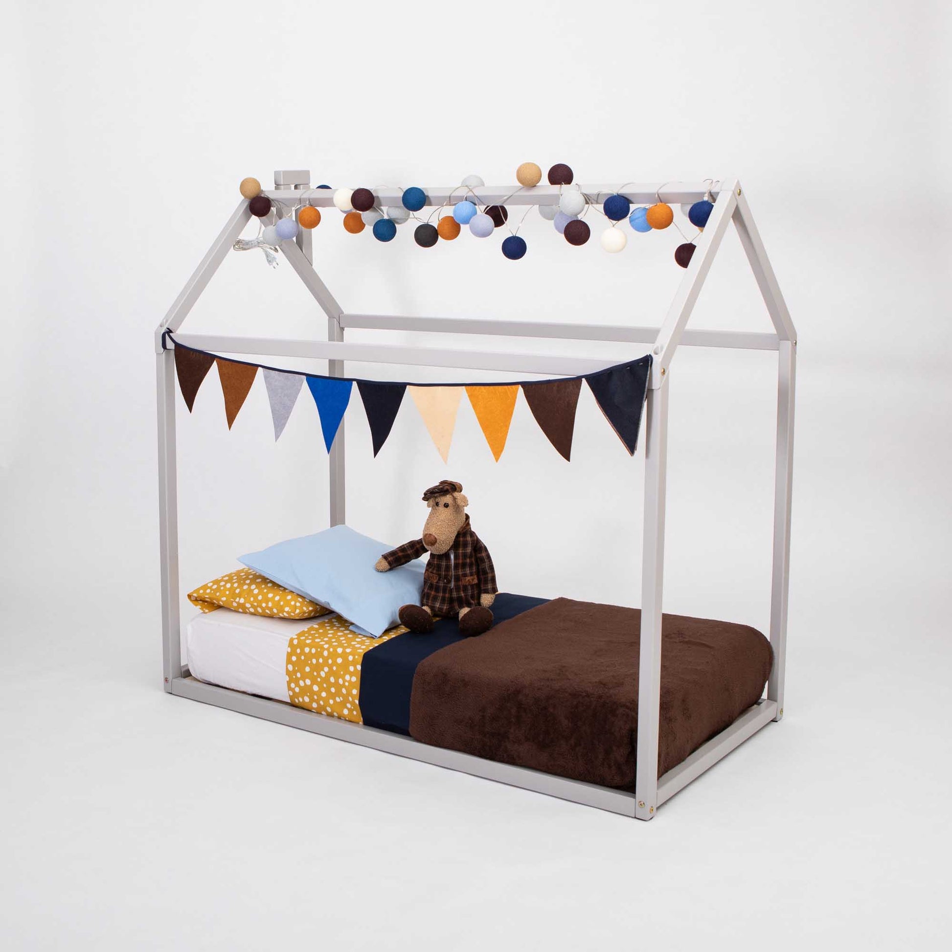 A Sweet Home From Wood Wooden zero-clearance house bed adorned with a cozy sleep haven featuring a teddy bear and bunting.