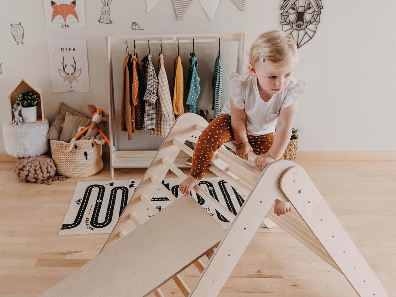 A little girl is playing with a wooden toy in her room.