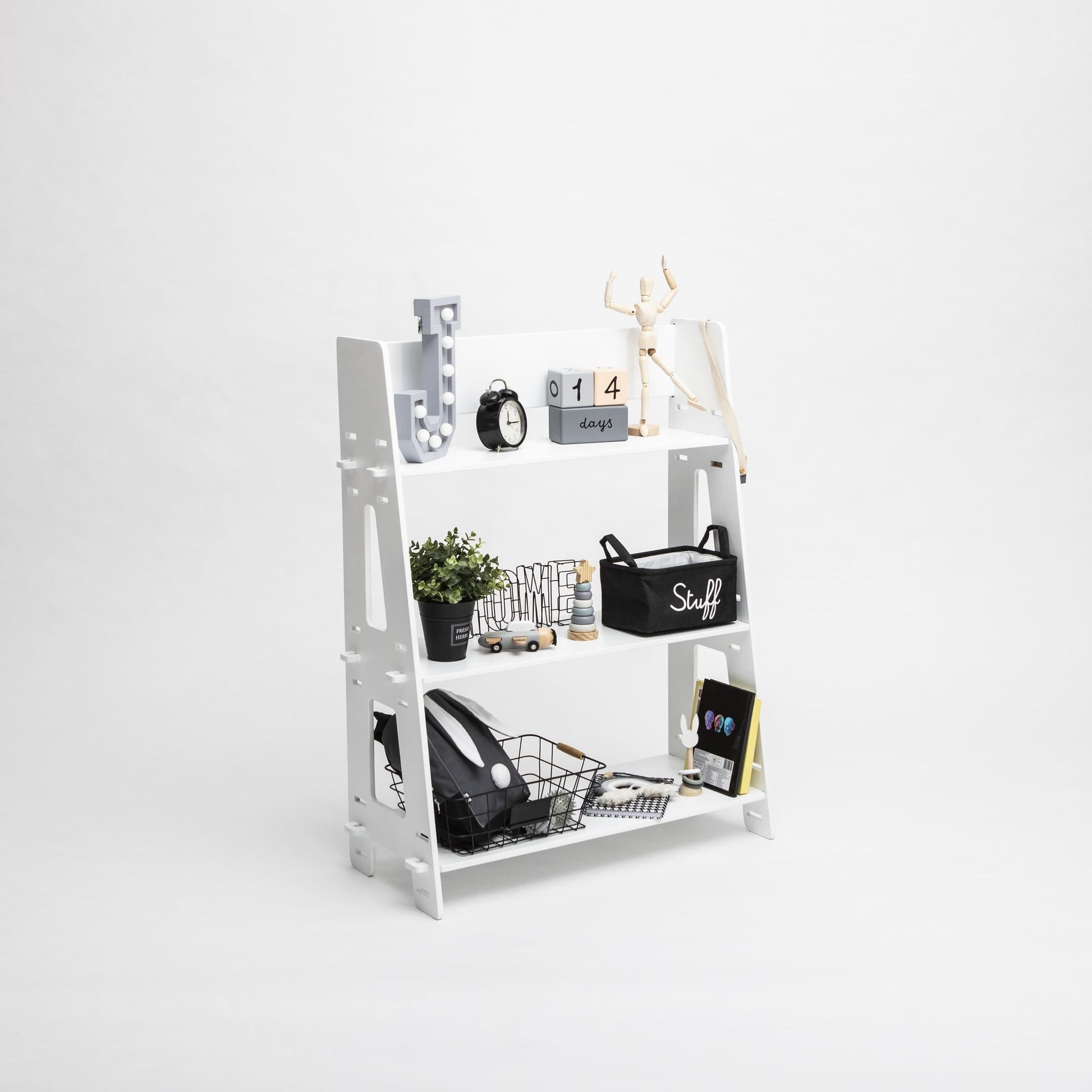 A Montessori toy shelf with various office supplies and decorative items, neatly organized for a child's bedroom.