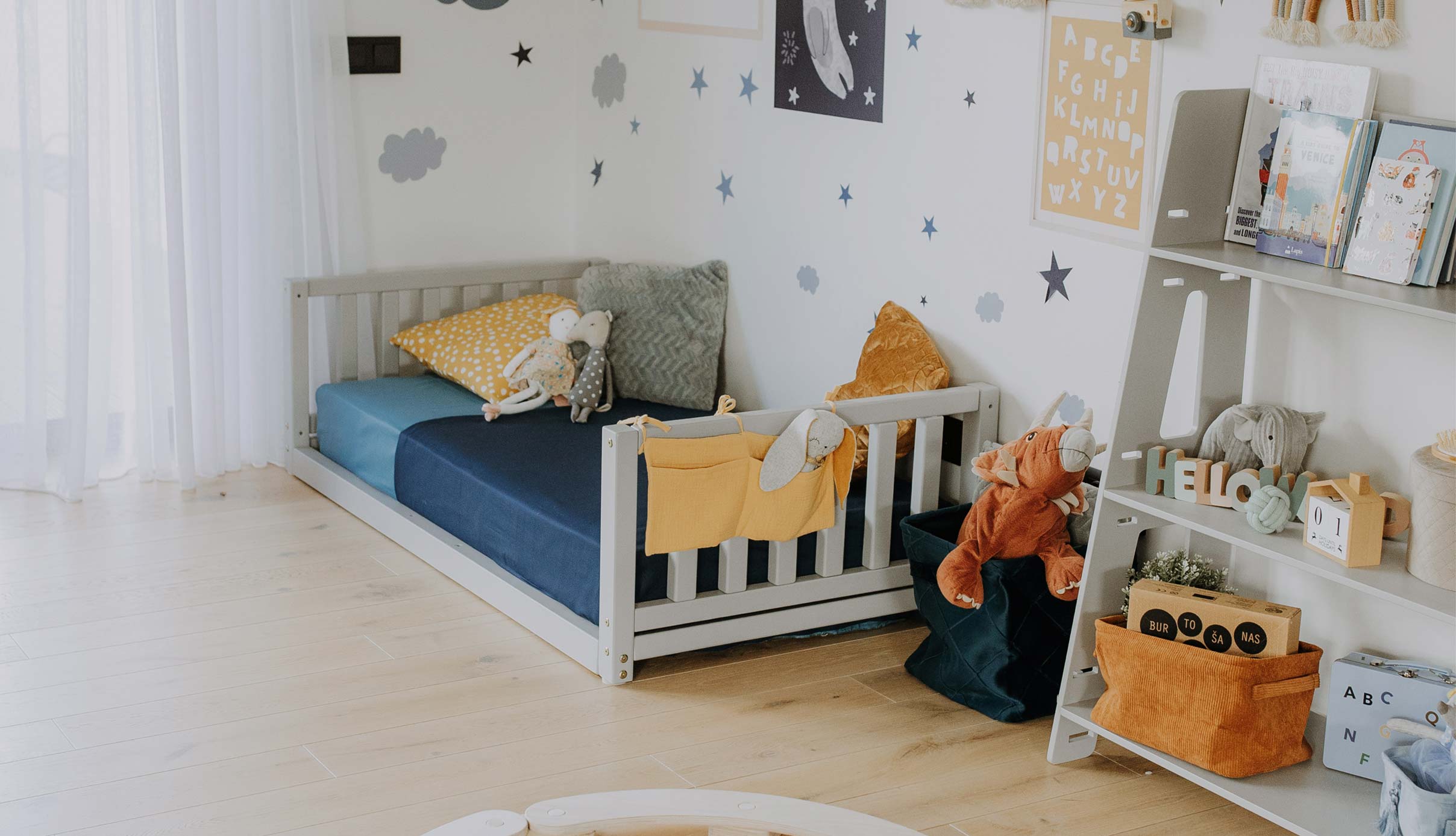 A child's room with a bed, bookshelf, and toys.