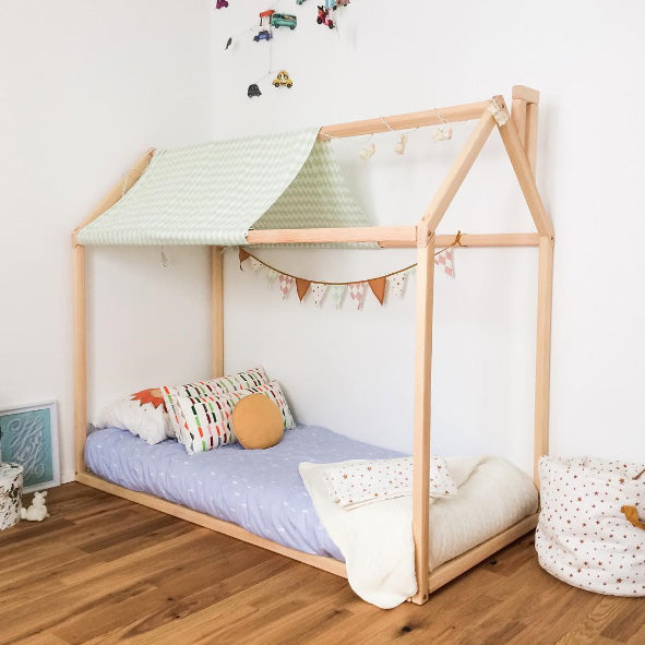 A child's room with a wooden house bed.