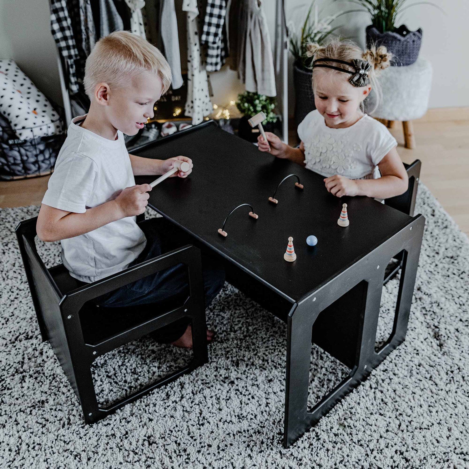 Two children playing at a table in a living room.