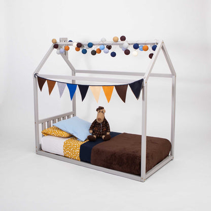 A Sweet Home From Wood house-frame bed with a headboard, with a cozy sleep haven adorned with bunting and a teddy bear.