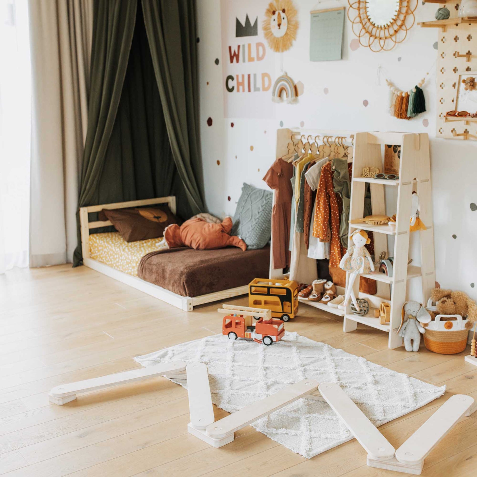 A child's room with a Sweet Home From Wood toddler floor bed with a horizontal rail headboard and toys.