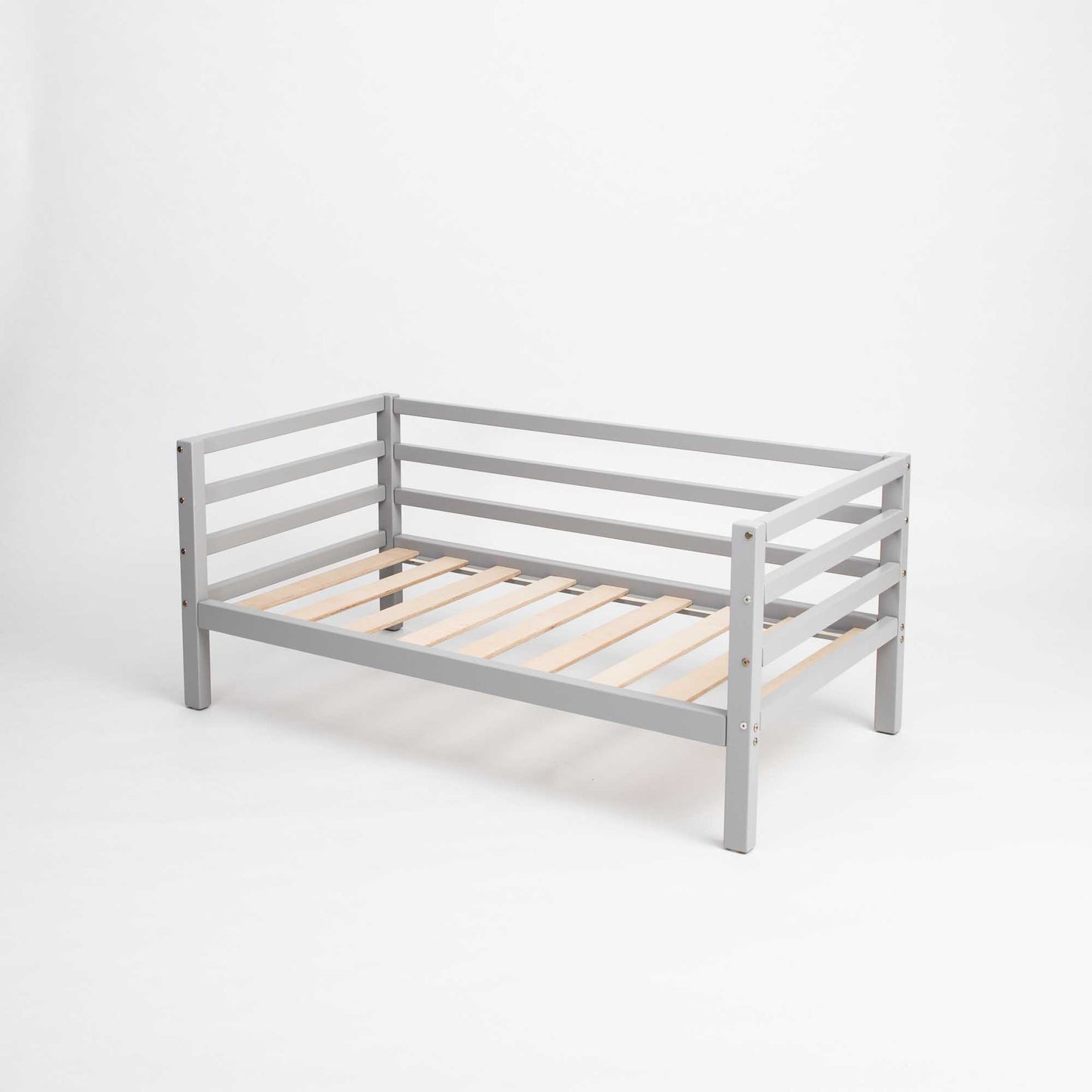 Kids' bed on legs with horizontal rail on 3-sides, made of solid gray wood, shown on a plain white background.