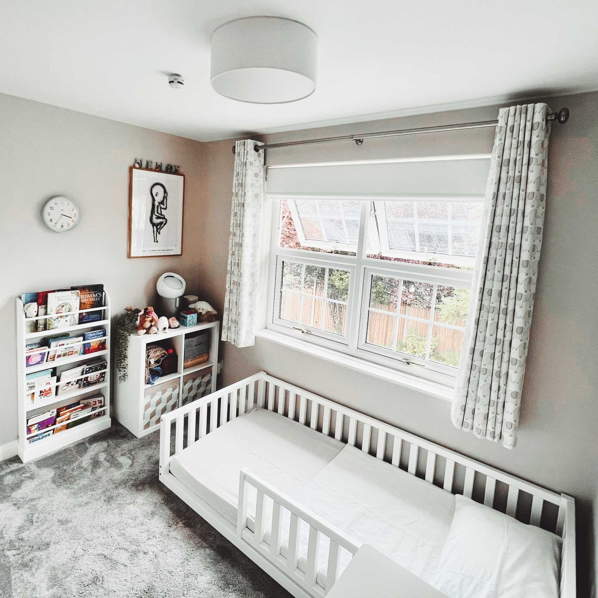 An independent sleeping space for a child with a Sweet Home From Wood Montessori kids' bed with a fence and a window providing security.