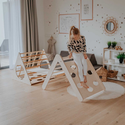 A girl playing on a Montessori climber set, delighting in active and engaging play on the versatile and stimulating Montessori climbing structure.