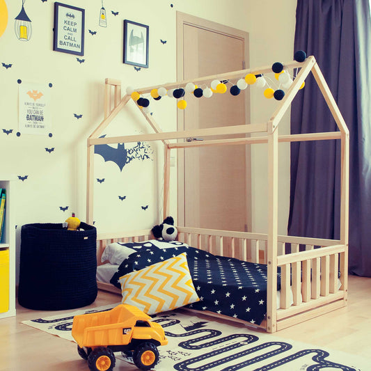 A Sweet Home From Wood Kids' house-frame bed with 3-sided rails transforms the boy's bedroom into a cozy sleep haven, featuring a comfortable bed accompanied by a playful toy truck.