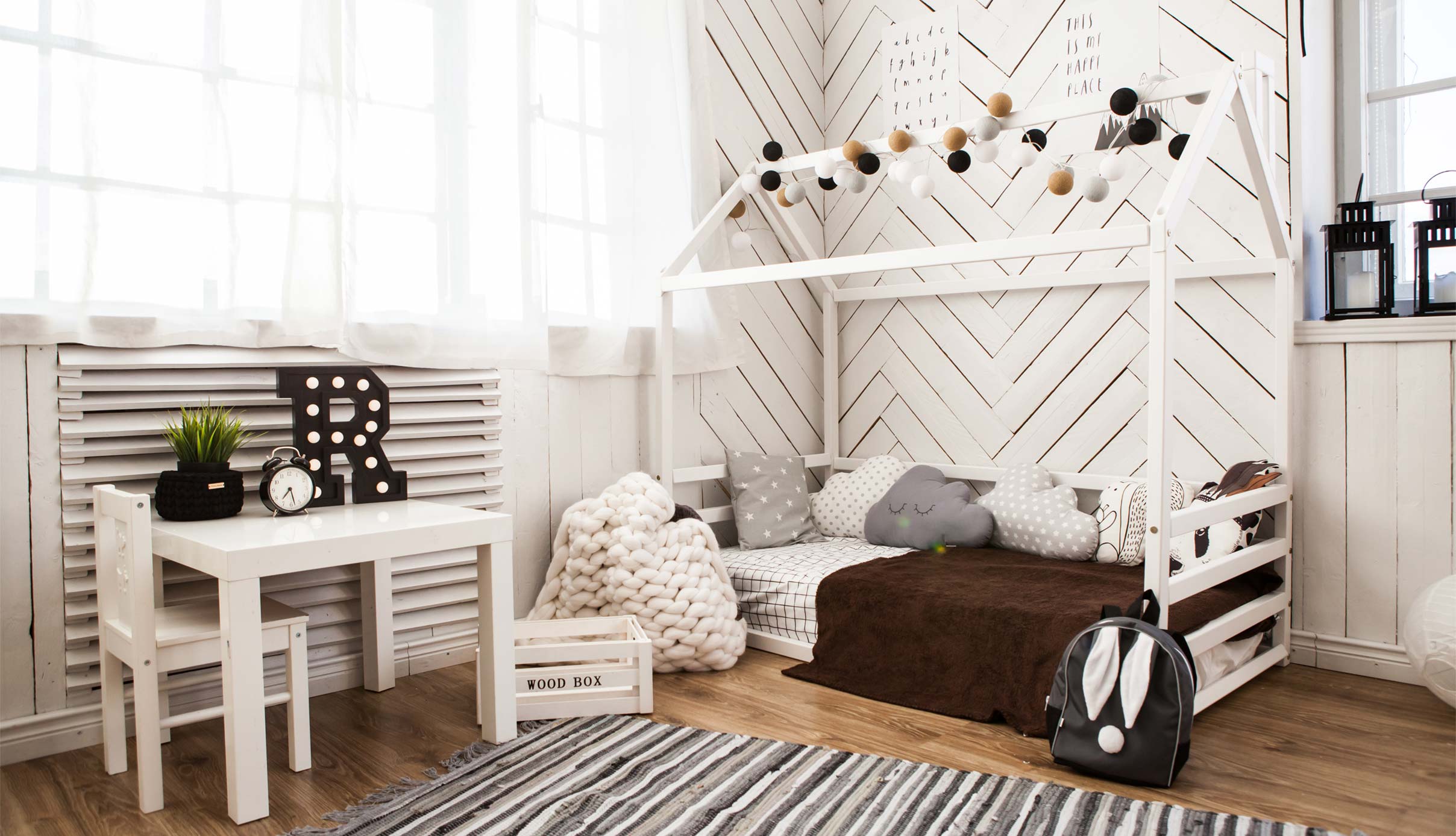 A child's room with a bed and a desk.