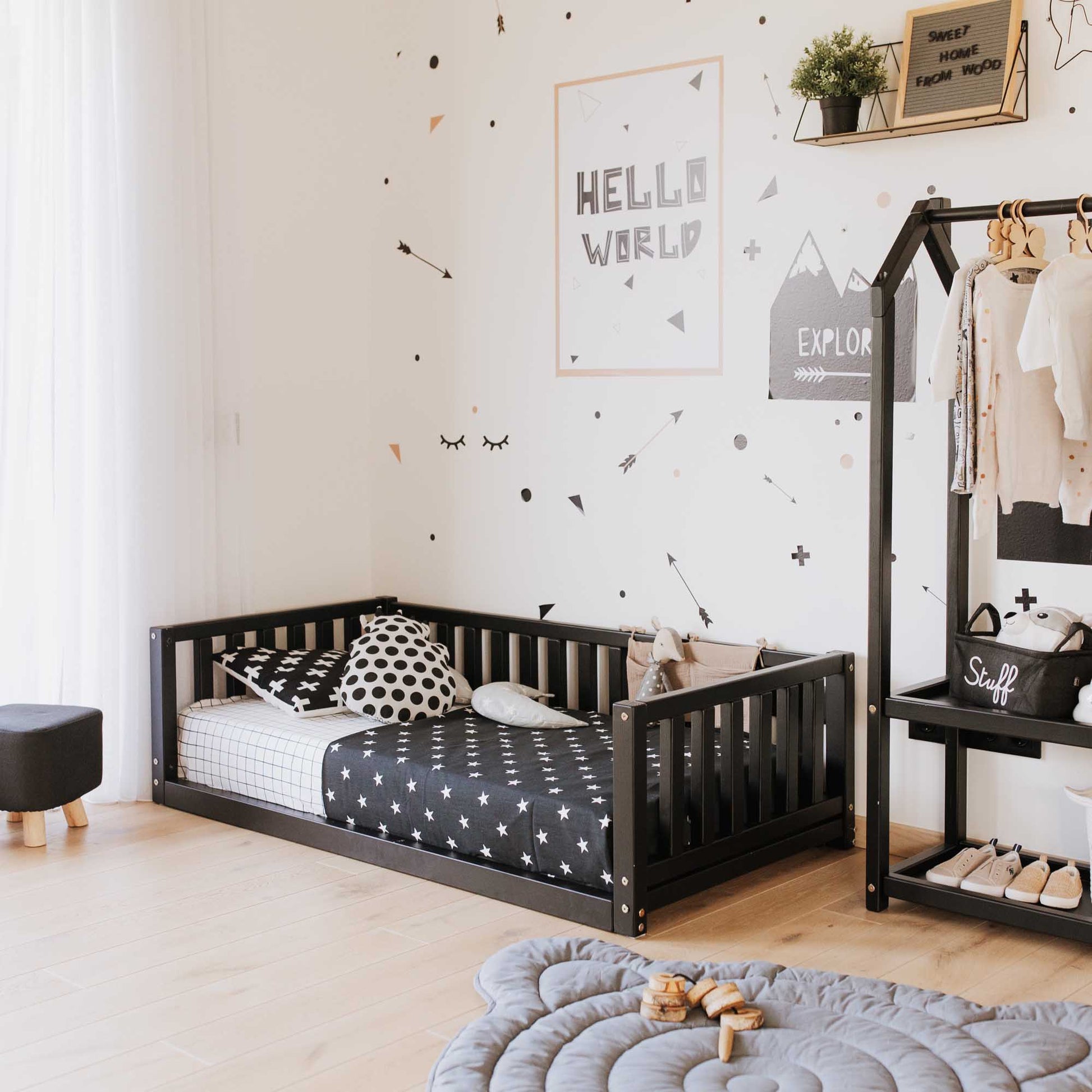 A Sweet Home From Wood floor-level children's room with a 2-in-1 toddler bed on legs with a 3-sided vertical rail and shelves.