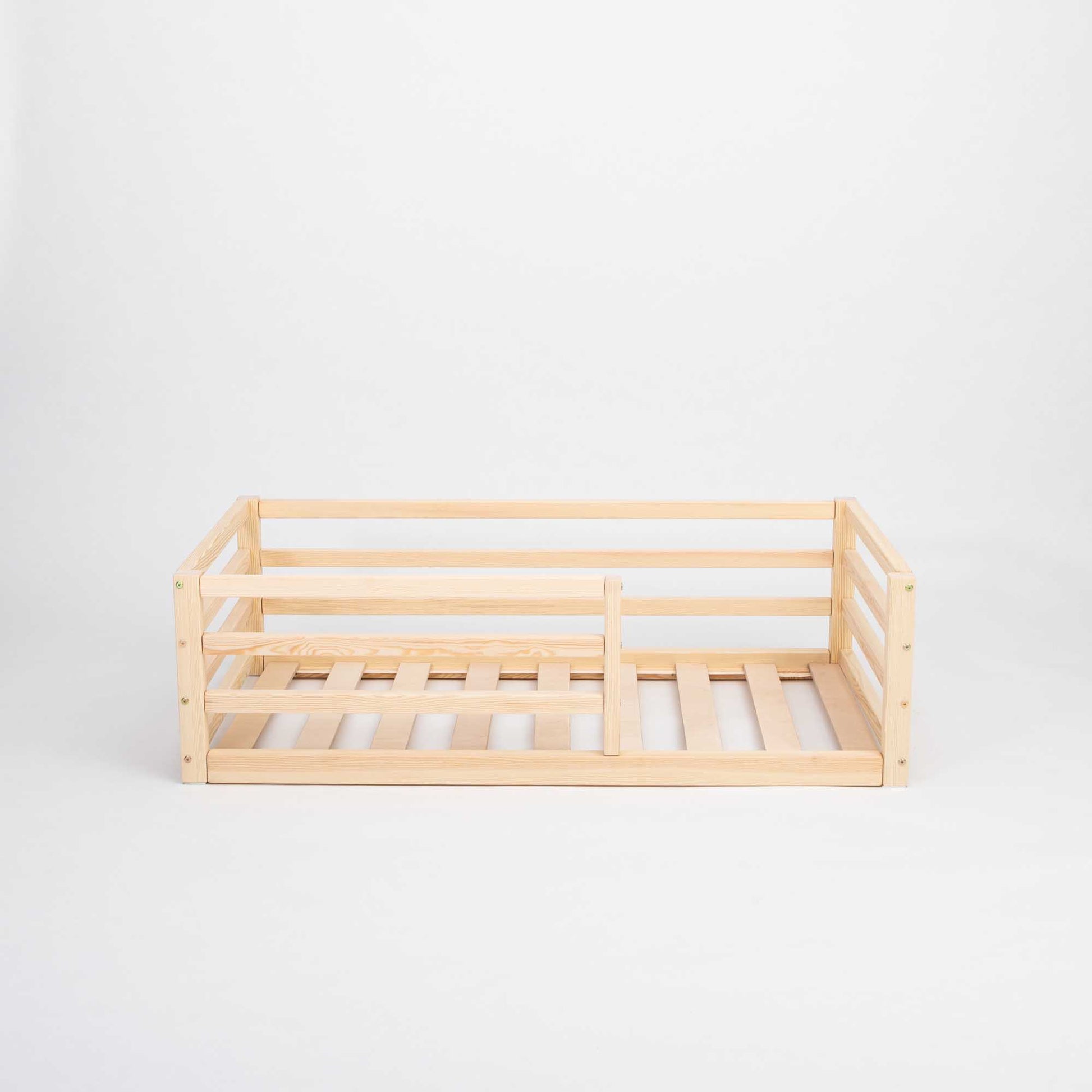 A Sweet Home From Wood floor-level kids' bed with a horizontal rail fence for independent sleeping, featuring a wooden divider.