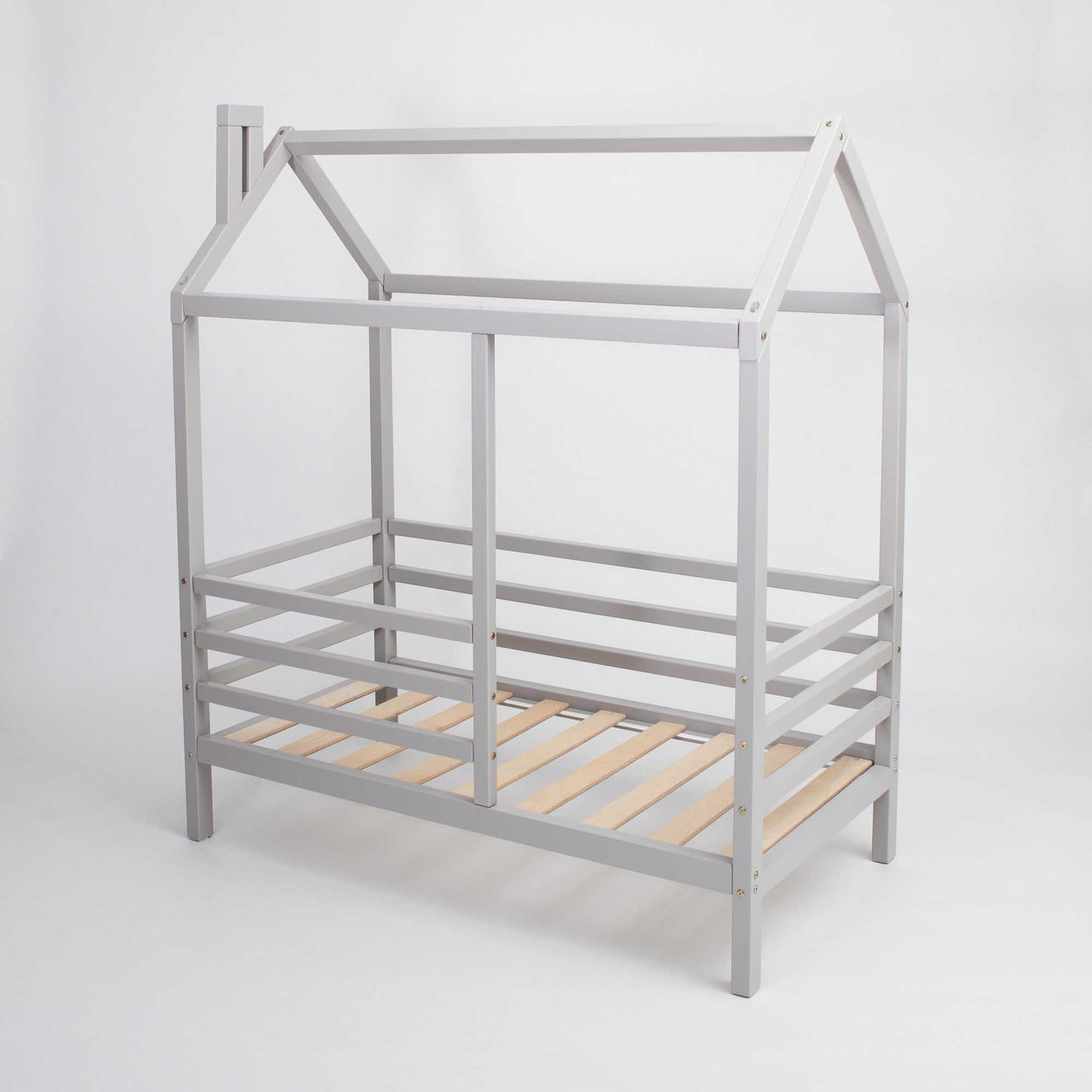 A Wooden house bed on legs with a fence with a grey frame and raised house bed.