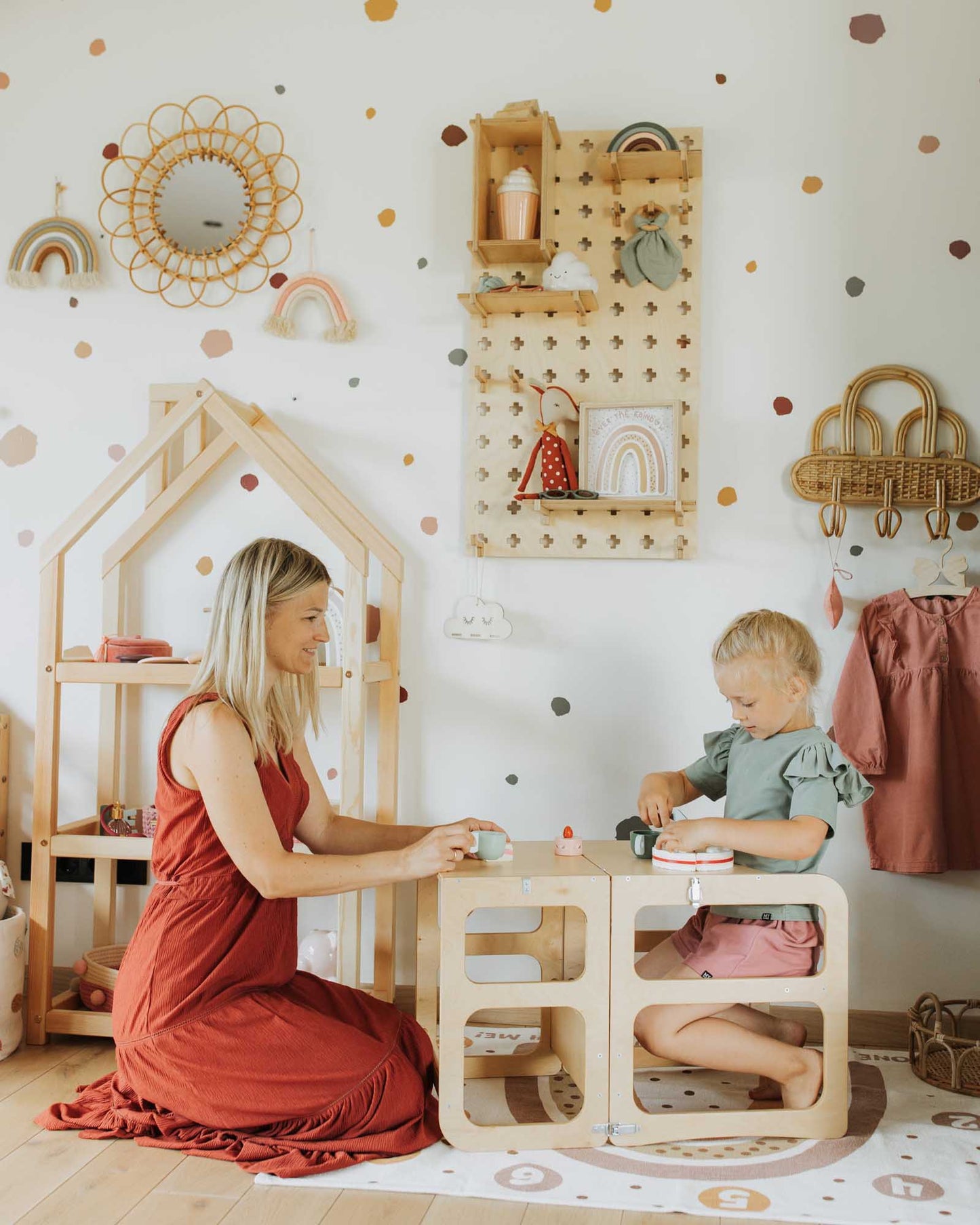 A woman and a child playing in a playroom with Sweet HOME from wood Floating Shelves Pegboard.