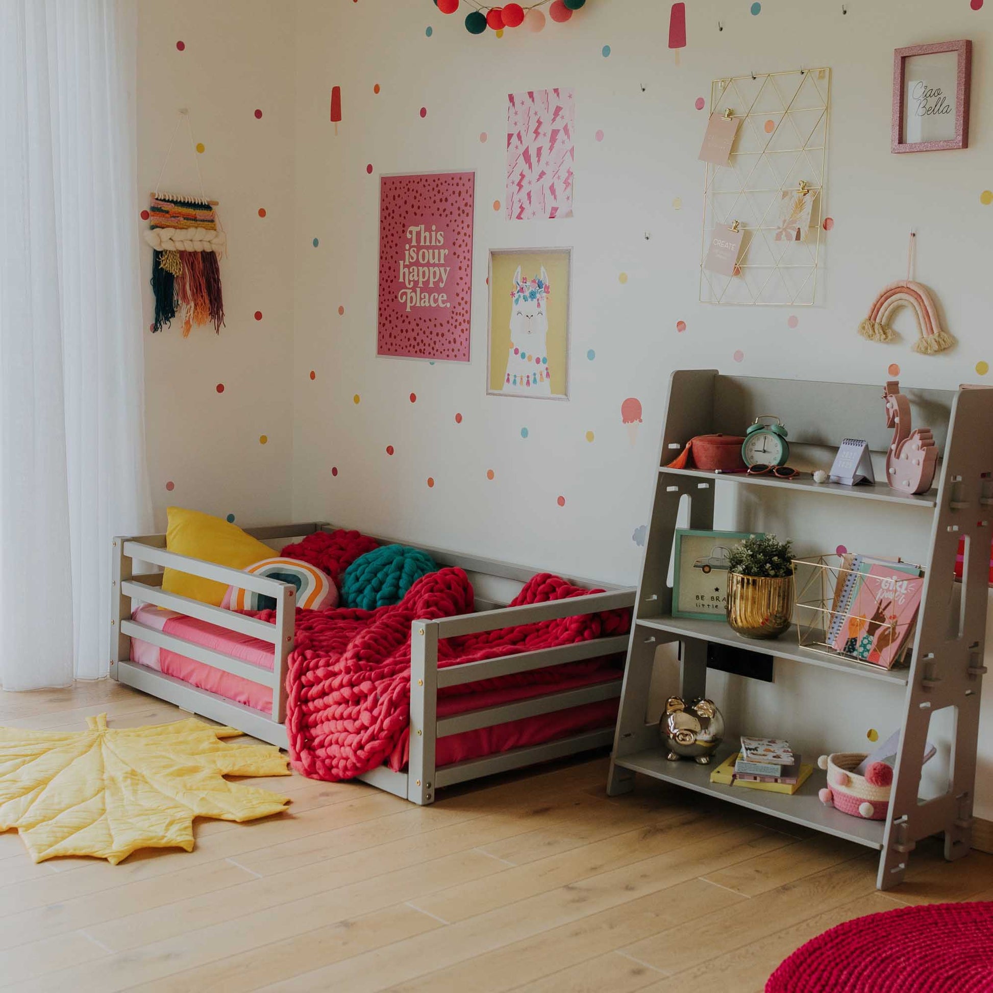 A child's room with a colorful polka dot wall and a Sweet Home From Wood 2-in-1 transformable kids' bed with a horizontal rail fence perfect for boys.