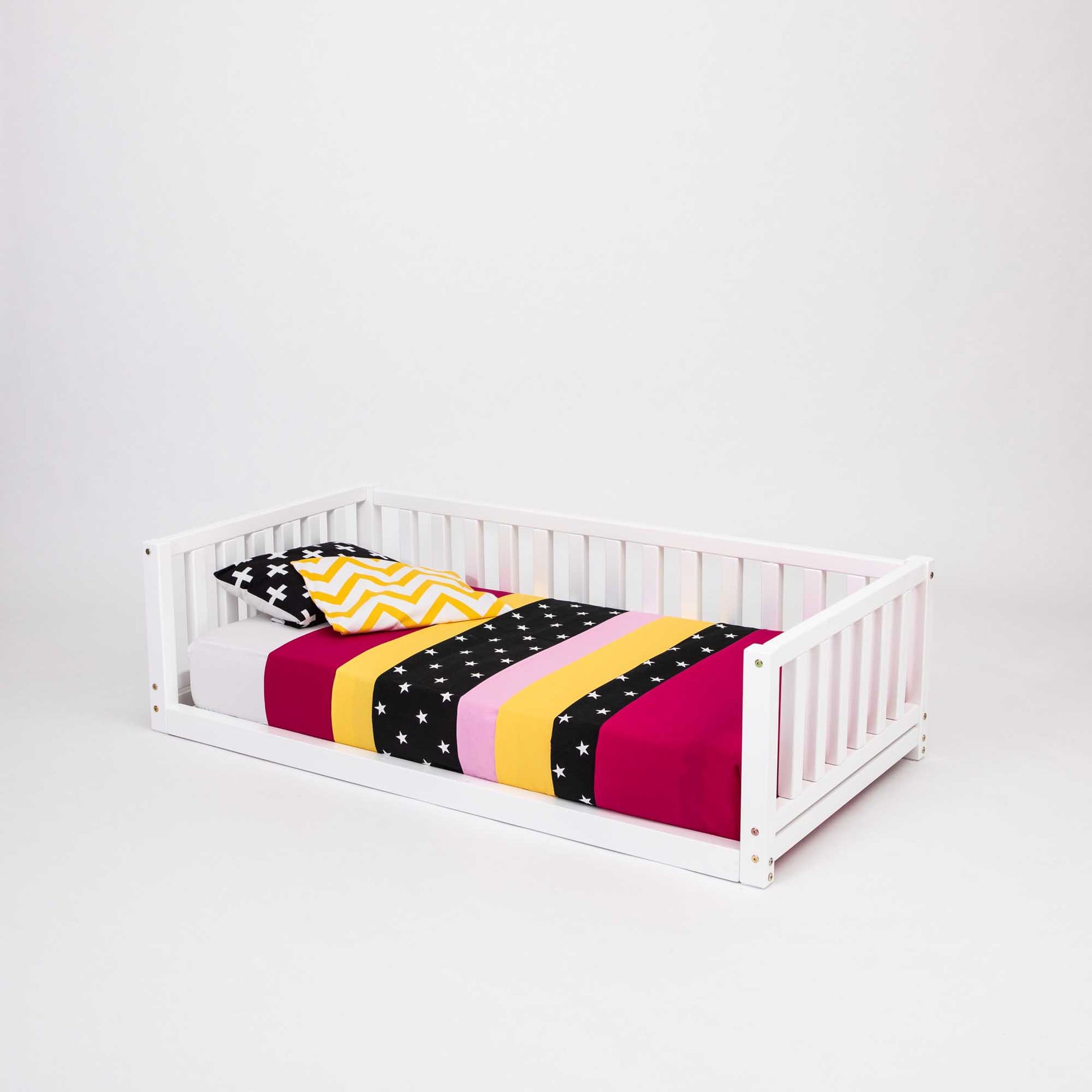 A Sweet Home From Wood 2-in-1 toddler bed on legs with a 3-sided vertical rail with a colorful striped blanket.