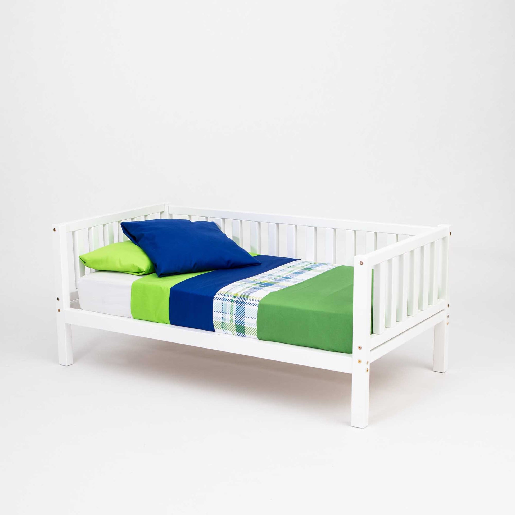 A white wooden 2-in-1 children's bed with green and blue bedding.
Product Name: Sweet Home From Wood's 2-in-1 toddler bed on legs with a 3-sided vertical rail
Brand Name: Sweet Home From Wood