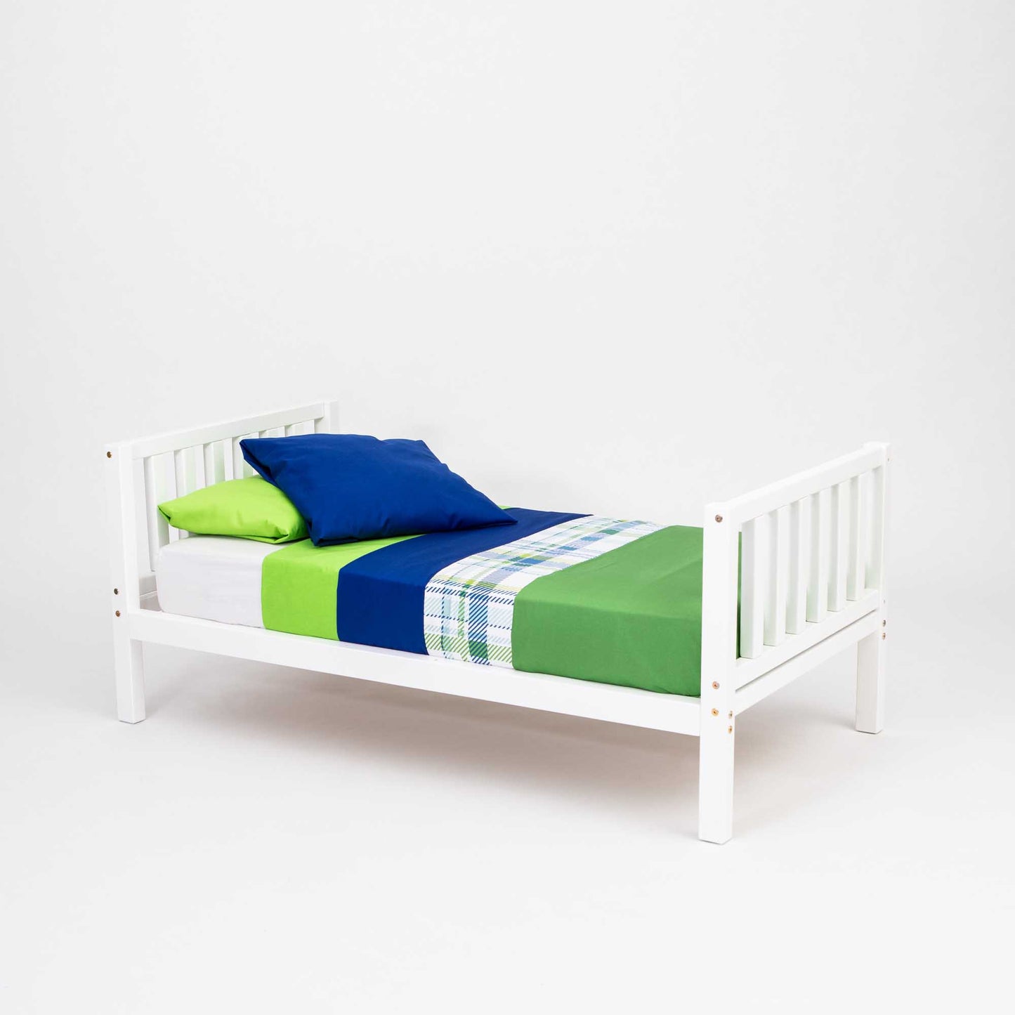 A 2-in-1 kid's bed on legs with a vertical rail headboard and footboard with green and blue bedding made of solid pine or birch wood.