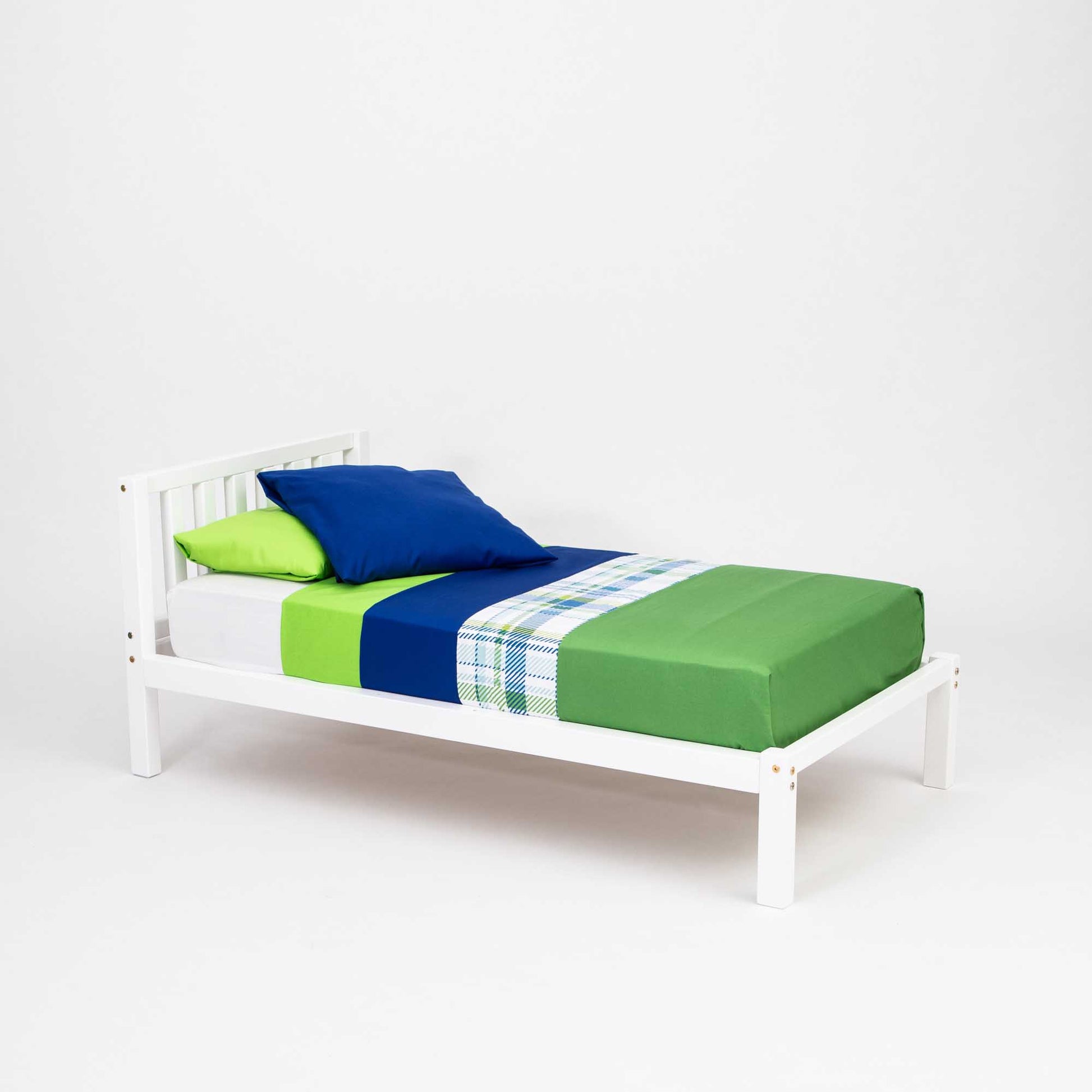 A 2-in-1 toddler bed on legs with a vertical rail headboard from the brand Sweet Home From Wood, adorned with a green and blue comforter.