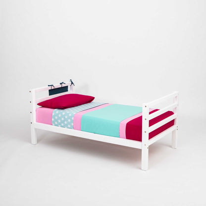 A Sweet Home From Wood 2-in-1 kids' bed with a horizontal rail headboard and footboard that grows with the child and features a pink and blue cover.