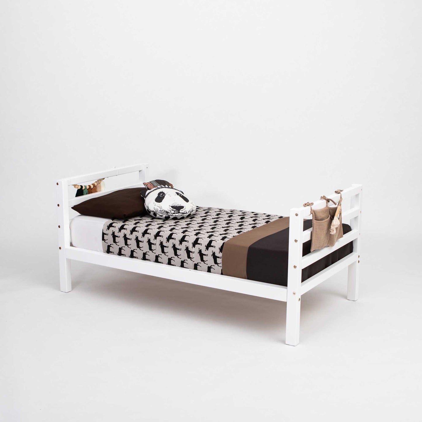 A Sweet Home From Wood Kids' bed on legs with a horizontal rail headboard and footboard, featuring a white wooden design and adorned with a black and brown pillow for comfortable co-sleeping.