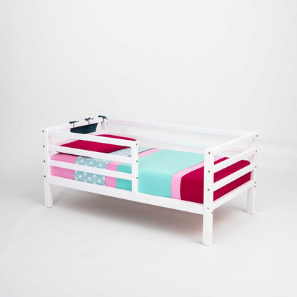A Kids' bed on legs with a horizontal rail fence from Sweet Home From Wood, with a pink and blue blanket, perfect for kids.