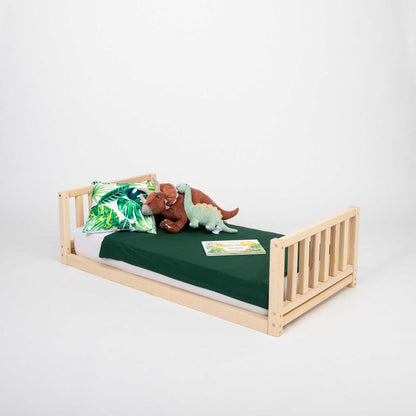 A 2-in-1 kid's bed on legs with a vertical rail headboard and footboard with a stuffed animal.