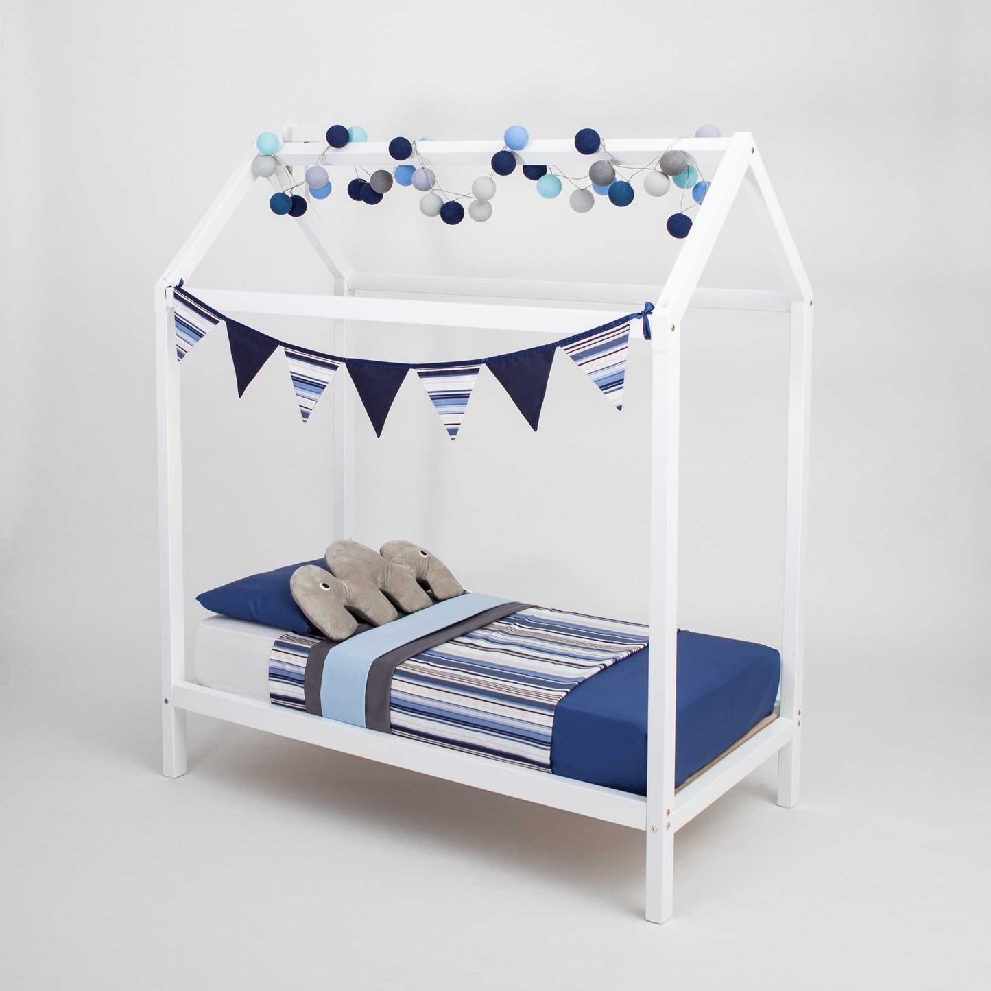 A boy's wooden house bed on legs with blue and white stripes and bunting.