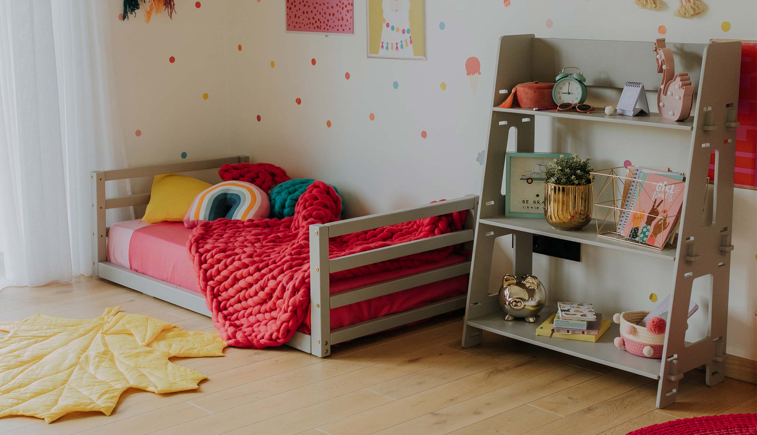 A girl's room with polka dots and a bed.