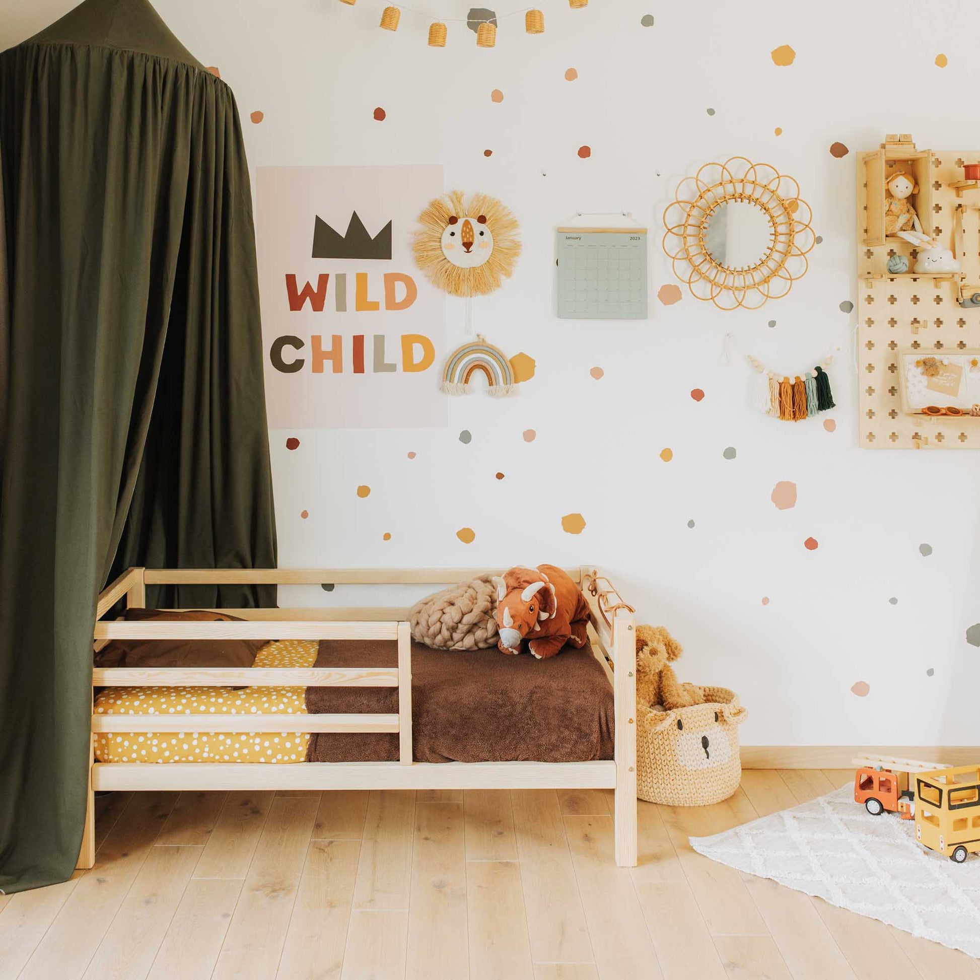 A child's room with a Sweet Home From Wood 2-in-1 transformable kids' bed with a horizontal rail fence, teddy bears, and polka dots.