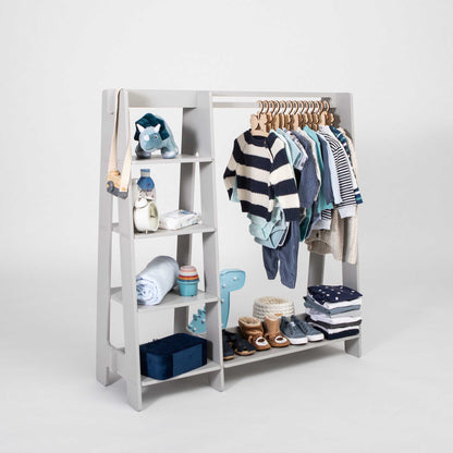 A Sweet Home From Wood Montessori-inspired children's wardrobe with dress up clothing hanging on it.