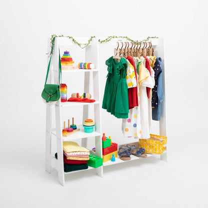 A Sweet Home From Wood Montessori-inspired children's wardrobe with storage shelves, featuring a white ladder rack with dress up clothing hanging on it.