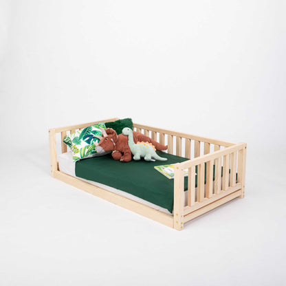 A Montessori-inspired, solid wood Montessori bed with 3-sided rails and a teddy bear on it.